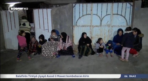 People sit on the pavement after an earthquake at an unknown location in Iraq 